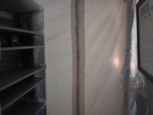 image of plastic wrapped shelves and zippered doorway to cleanroom